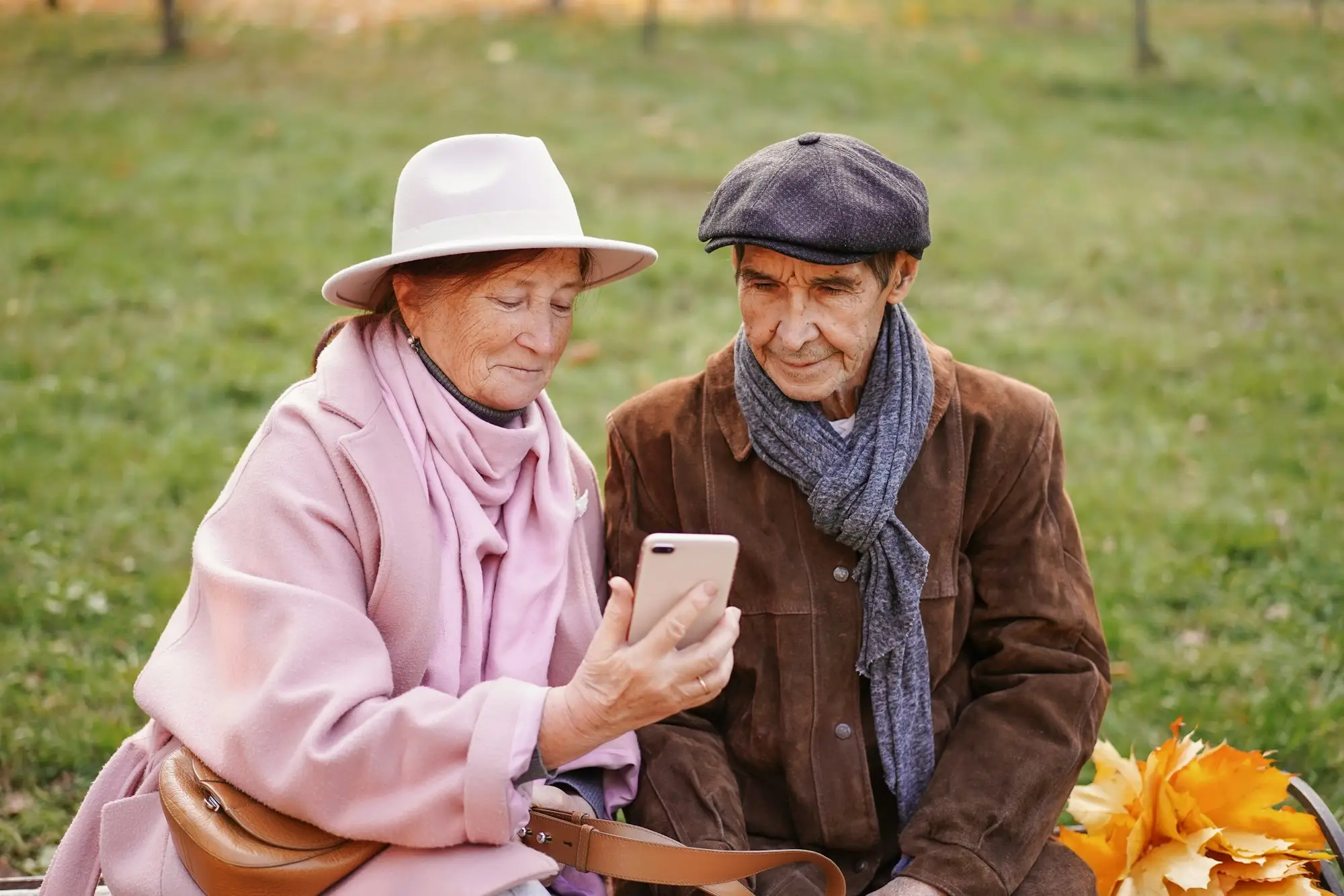 A happy European elderly couple who have lived together for 50 years sit on a bench and communicate